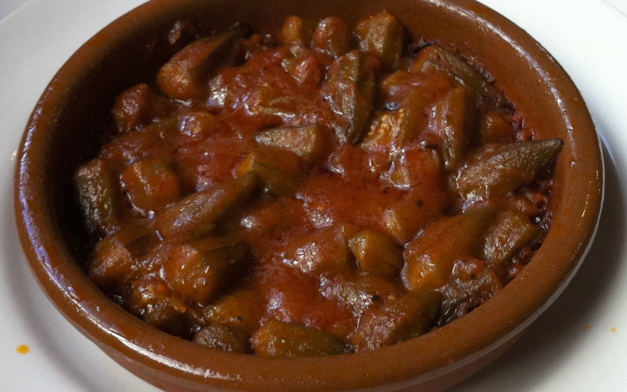 Okra in tomato sauce served in a shallow earthenware bowl