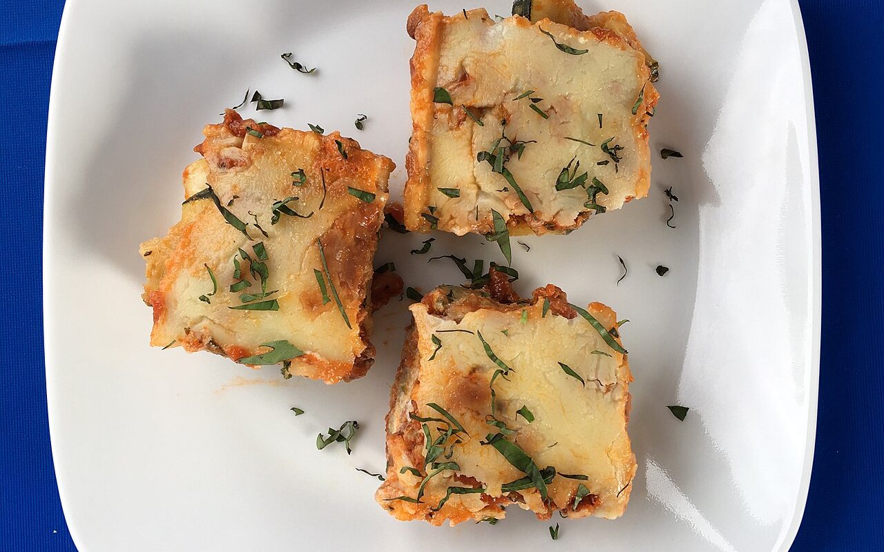 Layered zucchini casserole topped with browned melted cheese
