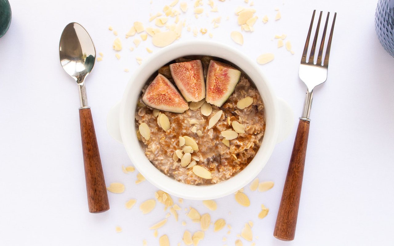 A bowl of oatmeal with chopped dried figs, almonds, and cinnamon